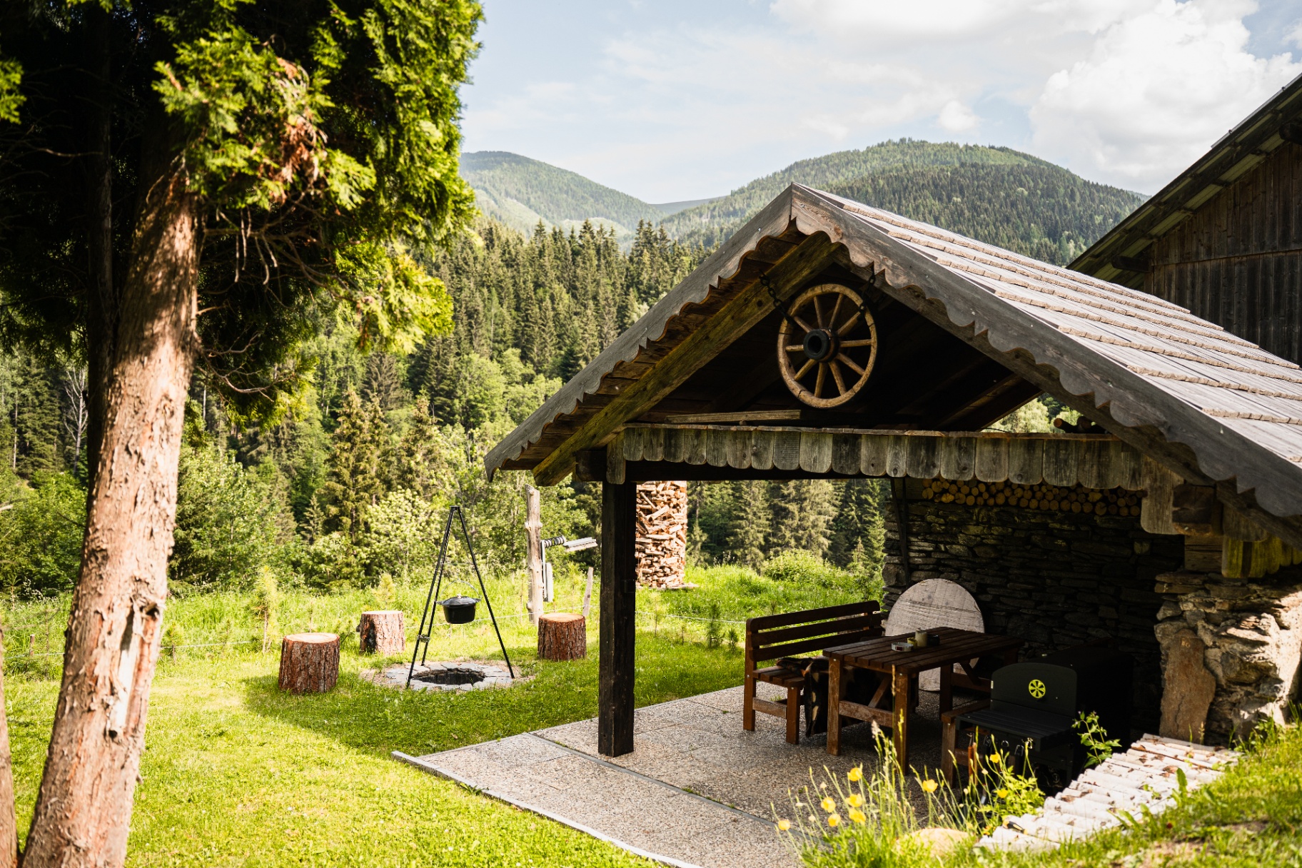 Gemütliche Grillhütte mit Wagenrad-Dekor und Bergblick in der Steiermark